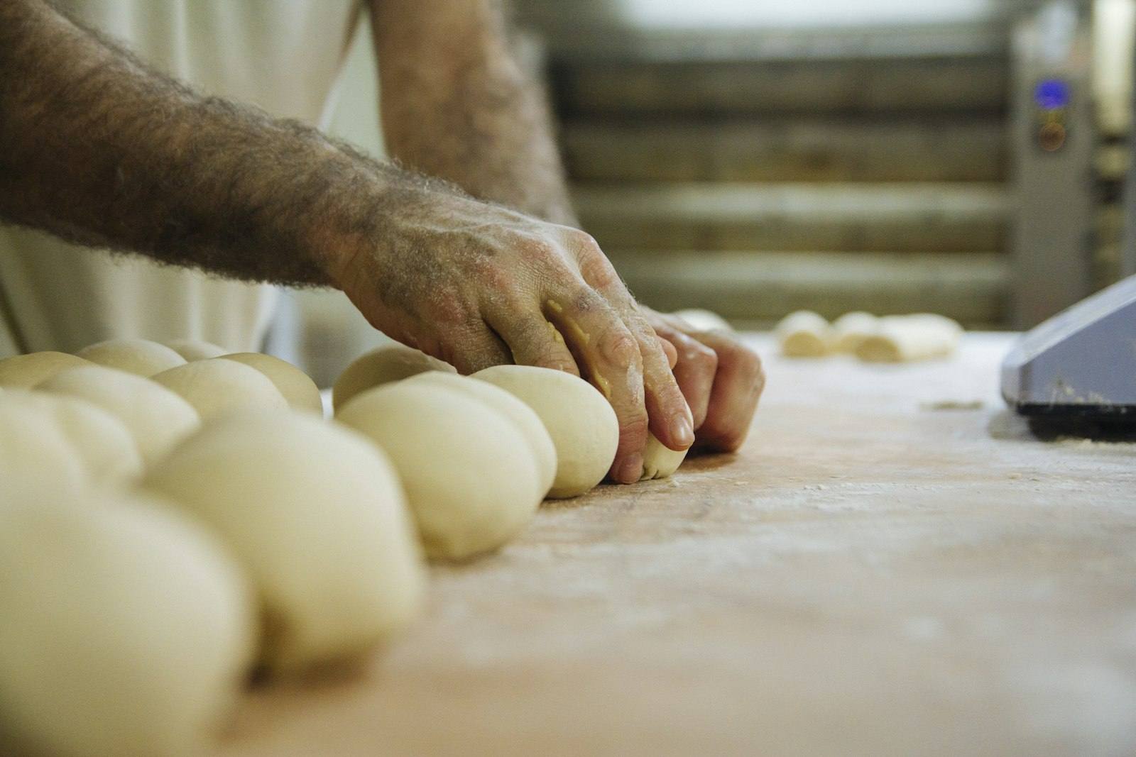 Mains d'un boulanger façonnant la pâte